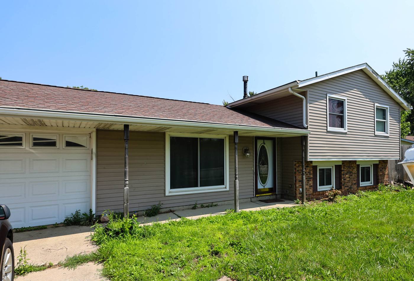 Split-level home with an overgrown lawn purchased as-is