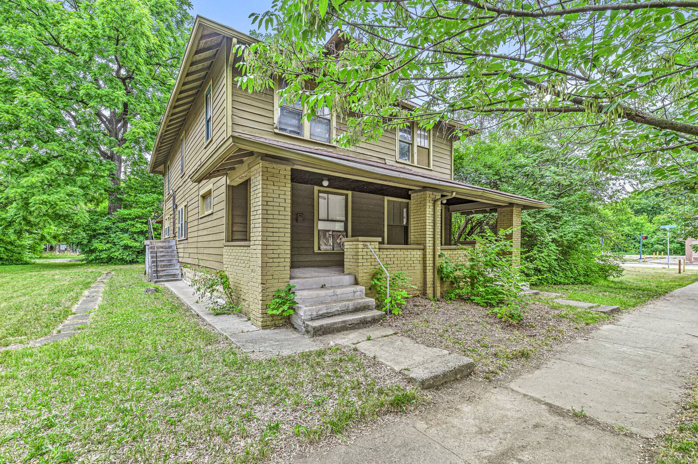 Craftsman home with overgrown yard purchased as-is